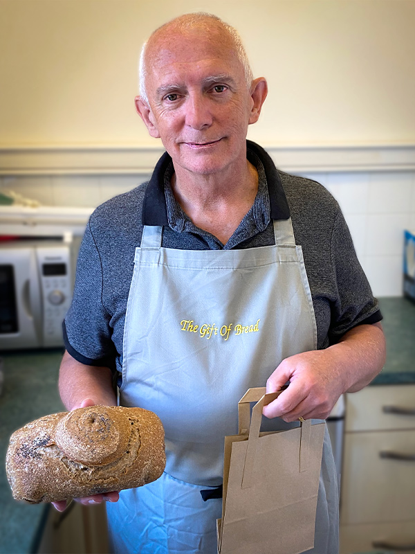 man with fresh baked sourdough loaf in class