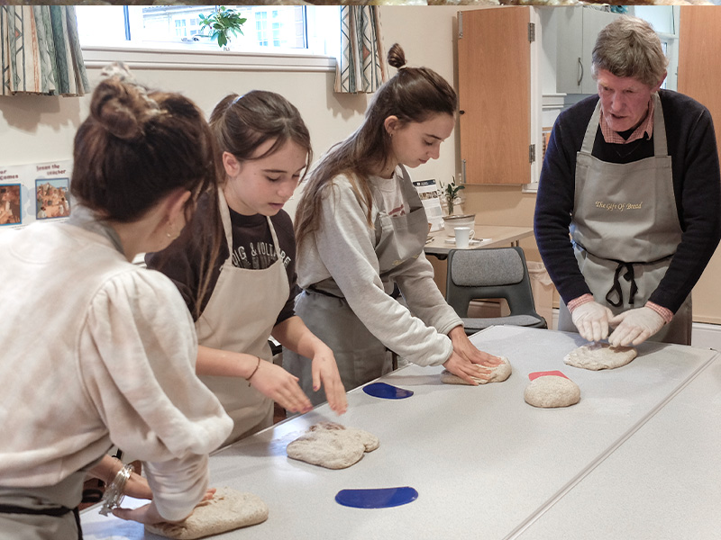 young girls shaping dough for sourdough loaves
